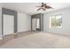 Open living room with neutral carpet, a ceiling fan, and views of the front yard at 24824 W Pueblo Ave, Buckeye, AZ 85326