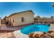 Outdoor living at its finest, featuring a sparkling pool, natural rock accents, and a shaded patio for comfortable lounging at 24824 W Pueblo Ave, Buckeye, AZ 85326