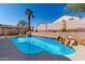Serene backyard retreat featuring a sparkling pool with rock features, creating a peaceful and inviting outdoor space for relaxation at 24824 W Pueblo Ave, Buckeye, AZ 85326