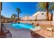 Relaxing backyard showcasing a clear blue pool, complemented by lush landscaping, and a shaded seating area for tranquil outdoor enjoyment at 24824 W Pueblo Ave, Buckeye, AZ 85326