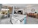 Granite island with stainless steel sink and seating overlooks dining and living areas through sliding doors at 266 N Piedra Way, Mesa, AZ 85207