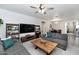 Cozy living room with modern furniture, a ceiling fan, and open access to the dining area at 266 N Piedra Way, Mesa, AZ 85207