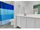 Bright bathroom featuring a blue striped shower curtain, white cabinets, and tile floors at 2708 S Santa Rita --, Mesa, AZ 85209