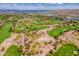 An aerial view of a lush green golf course with sand traps, and desert vegetation at 3252 E Fremont Rd, Phoenix, AZ 85042