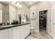 Well-lit bathroom with a gray tile floor, walk-in closet, large mirror, and updated vanity at 3252 E Fremont Rd, Phoenix, AZ 85042