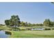 Scenic golf course view with a pond, bridge, mature trees, and lush green grass at 3252 E Fremont Rd, Phoenix, AZ 85042