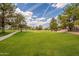 Well-maintained community green space with healthy green grass, mature trees, and a walking path at 3252 E Fremont Rd, Phoenix, AZ 85042