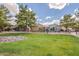 Neighborhood green space with manicured lawns, mature trees, rocks, and lush landscaping at 3252 E Fremont Rd, Phoenix, AZ 85042