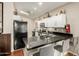 Modern kitchen features black countertops, white cabinets, and a breakfast bar with seating at 3252 E Fremont Rd, Phoenix, AZ 85042