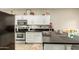 Well-lit kitchen with stainless steel appliances, white cabinetry, and a black countertop island at 3252 E Fremont Rd, Phoenix, AZ 85042