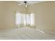 A spacious bedroom has neutral carpeting, a ceiling fan, and large windows with natural light at 3407 W Steinbeck Dr, Anthem, AZ 85086