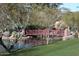 Scenic view of a red pedestrian bridge over a pond in the community park at 3407 W Steinbeck Dr, Anthem, AZ 85086