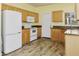 Functional kitchen featuring wood cabinets, white appliances, granite counters, and durable flooring at 3407 W Steinbeck Dr, Anthem, AZ 85086