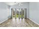 Bright living room with wood-style floors, large windows, and sliding glass doors to the backyard at 3407 W Steinbeck Dr, Anthem, AZ 85086