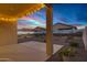 Covered patio with string lights overlooks a backyard with desert landscaping and block wall at 40005 W Rio Lobo Dr, Maricopa, AZ 85138