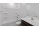 Clean bathroom featuring white tub, toilet and vanity with a sink and dark wood cabinets at 40005 W Rio Lobo Dr, Maricopa, AZ 85138