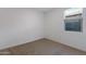A simple bedroom offers neutral carpet, white walls, and a bright, natural light from window at 40005 W Rio Lobo Dr, Maricopa, AZ 85138