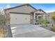 Charming exterior featuring a large garage, covered porch, and desert landscaping at 40005 W Rio Lobo Dr, Maricopa, AZ 85138