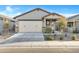Charming single-story home featuring a two-car garage and desert landscaping in front yard at 40005 W Rio Lobo Dr, Maricopa, AZ 85138