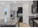 Stainless steel refrigerator and kitchen island featuring dark cabinetry and granite countertops at 40005 W Rio Lobo Dr, Maricopa, AZ 85138