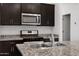 A detailed view of a stainless steel kitchen sink with granite countertops and stainless steel appliances at 40005 W Rio Lobo Dr, Maricopa, AZ 85138
