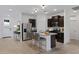 Modern kitchen with dark cabinets, stainless steel appliances, and a granite island with seating at 40005 W Rio Lobo Dr, Maricopa, AZ 85138