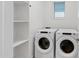 Bright laundry room with a window, modern Whirlpool washer and dryer, and storage shelving at 40005 W Rio Lobo Dr, Maricopa, AZ 85138