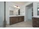 Modern bathroom with wood vanity, dual sinks, white countertop and tiled flooring at 40101 N Alameda Dr, San Tan Valley, AZ 85140