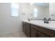 Modern bathroom featuring a wood vanity, white countertop, dual sinks, and tiled flooring at 40101 N Alameda Dr, San Tan Valley, AZ 85140