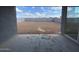View of the large dirt backyard, seen through patio doors, offering possibilities for outdoor design at 4329 E Brook Lynn Pl, San Tan Valley, AZ 85143