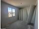Bright bedroom with a large window, showing door installation, with neutral walls and flooring at 4329 E Brook Lynn Pl, San Tan Valley, AZ 85143