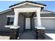Close-up of a covered front porch with stone pillars, a white front door, and neutral siding at 4329 E Brook Lynn Pl, San Tan Valley, AZ 85143