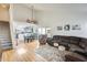 Bright living room featuring wood floors, a vaulted ceiling, and an open layout with gray kitchen cabinets at 4343 E Contessa St, Mesa, AZ 85205