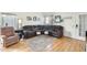 Comfortable living room with a brown leather sectional sofa, wood flooring and access to the back yard at 4343 E Contessa St, Mesa, AZ 85205