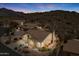 Desert home at dusk, with desert landscaping, stone accents and exterior lighting at 4903 S Desert Willow Dr, Gold Canyon, AZ 85118