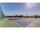 Brightly painted tennis courts with nets and basketball hoop surrounded by mature landscaping under clear skies at 4903 S Desert Willow Dr, Gold Canyon, AZ 85118