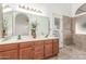 Well-lit bathroom featuring double sinks, a large mirror, and a tiled shower at 5016 E Waltann Ln, Scottsdale, AZ 85254