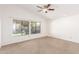 Spacious carpeted bedroom featuring a ceiling fan and a large window at 5016 E Waltann Ln, Scottsdale, AZ 85254