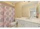 Clean bathroom with a large mirror, sink, toilet, and shower with patterned curtain at 5206 N 16Th Dr, Phoenix, AZ 85015