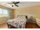 Inviting bedroom with a ceiling fan, wood floors, a large window, and a cozy quilt on the bed at 5206 N 16Th Dr, Phoenix, AZ 85015