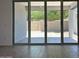 View of the backyard through glass sliding doors to a covered patio at 5519 S 240Th Ln, Buckeye, AZ 85326