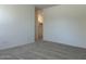 A simple carpeted bedroom with plain walls and an entrance to the closet at 5519 S 240Th Ln, Buckeye, AZ 85326