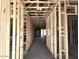 Unfinished interior view down a hallway showing the frame, electrical and plumbing at 5519 S 240Th Ln, Buckeye, AZ 85326