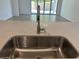 Modern kitchen with stainless steel faucet and views of the large sliding glass doors in the back at 5519 S 240Th Ln, Buckeye, AZ 85326