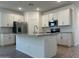 Open kitchen with white cabinetry, stainless appliances, and center island with bar seating at 5519 S 240Th Ln, Buckeye, AZ 85326