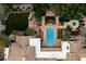 Aerial view of a luxurious estate with a large pool, outdoor living spaces, and meticulously landscaped grounds at 6402 E Chaparral Rd, Paradise Valley, AZ 85253