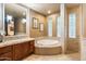 Relaxing bathroom with tub, wooden vanity, and tiled walk-in shower, perfect for unwinding at 6402 E Chaparral Rd, Paradise Valley, AZ 85253