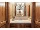 Nicely appointed bathroom with wood cabinets, a vanity with a sink, and an elegant mirror at 6402 E Chaparral Rd, Paradise Valley, AZ 85253