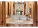 Well-lit bathroom featuring a wooden vanity with a sink, mirror, and decorative mosaic tile backsplash at 6402 E Chaparral Rd, Paradise Valley, AZ 85253