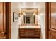 Charming bathroom with wooden cabinets, tile countertop, a large mirror, and decorative lighting at 6402 E Chaparral Rd, Paradise Valley, AZ 85253